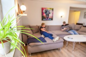 To personer, der ligger i sofaen på Paideia - et opholdssted for børn og unge med omsorgssvigt og særlige behov på Sjælland. Søger du efter opholdssteder eller bosteder for unge med problemer, så kontakt os!